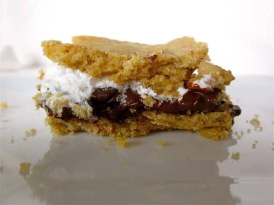 Τραγανή μπάρα s'mores με μπισκοτένια βάση, σοκολάτα και μαρσμέλοου σε λευκό φόντο.