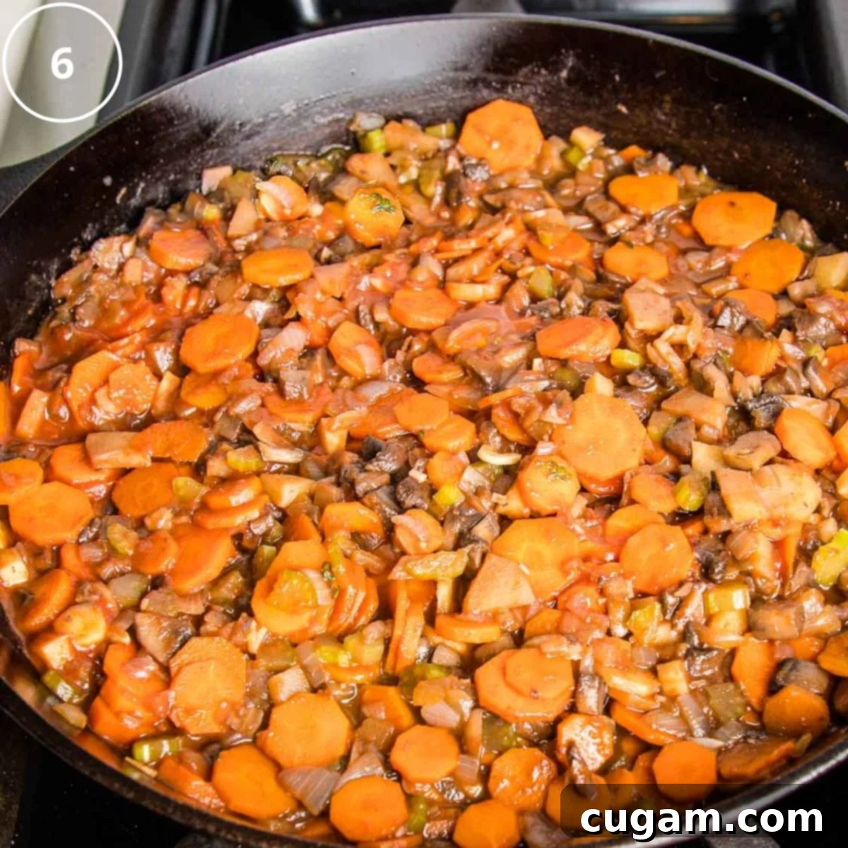 Cast iron skillet filled with vegetable filling for shepherd's pie.