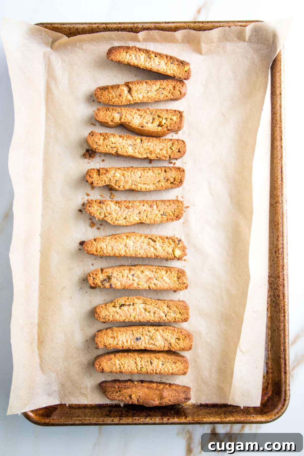 Sliced biscotti on a baking tray lined with parchment after the second bake. 