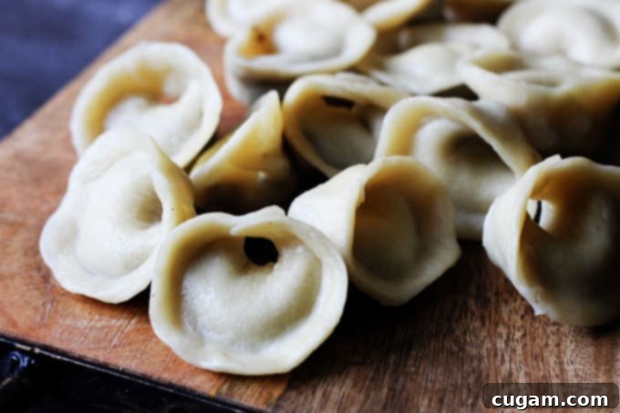Mushroom pierogi Uszka neatly arranged on a wooden board, ready for storage or serving.