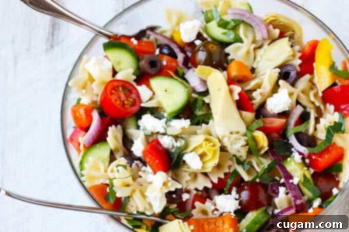 Farfalle Pasta Salad Mediterranean Style is a great pasta salad with super fresh ingredients like cucumbers, tomatoes, onions and peppers. Extra flavors come form Kalamata Olives, marinated artichokes and feta cheese. Dressed with red wine based vinaigrette instead of mayo makes for super light and refreshing side dish.