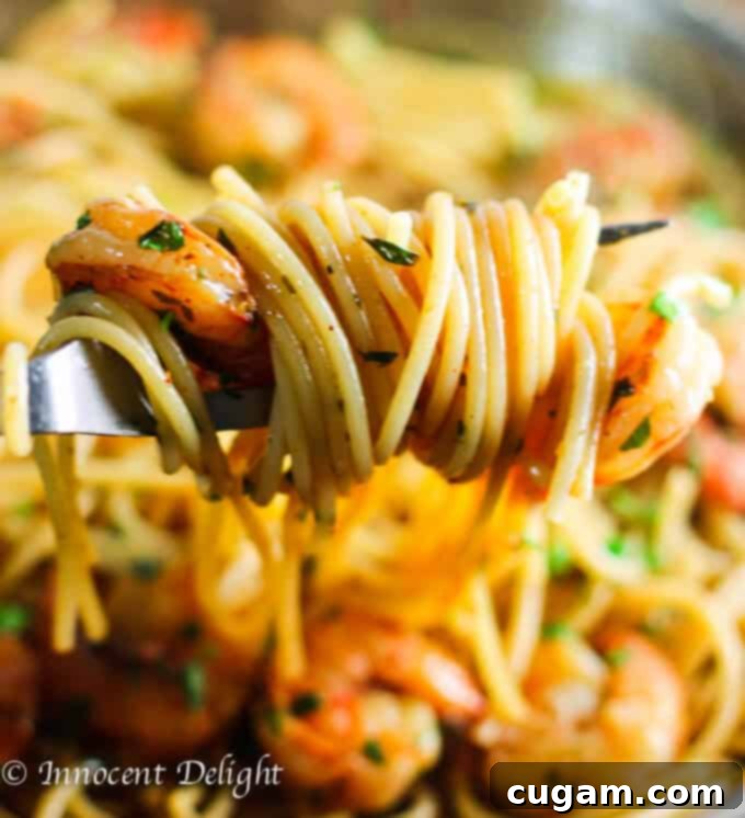 Shrimp Scampi Pasta on a fork, showcasing the tender shrimp and vibrant sauce