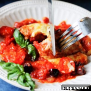 Veal Rollatini Stuffed with Peppers, Cheese, and Basil in a Rich Tomato Olive Sauce 15 Veal Rollatini on a plate with fork and knife