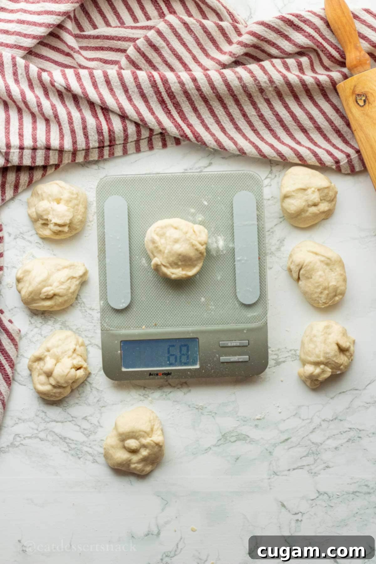Balls of raw tortilla dough on a countertop next to a kitchen scale for precise measurement.