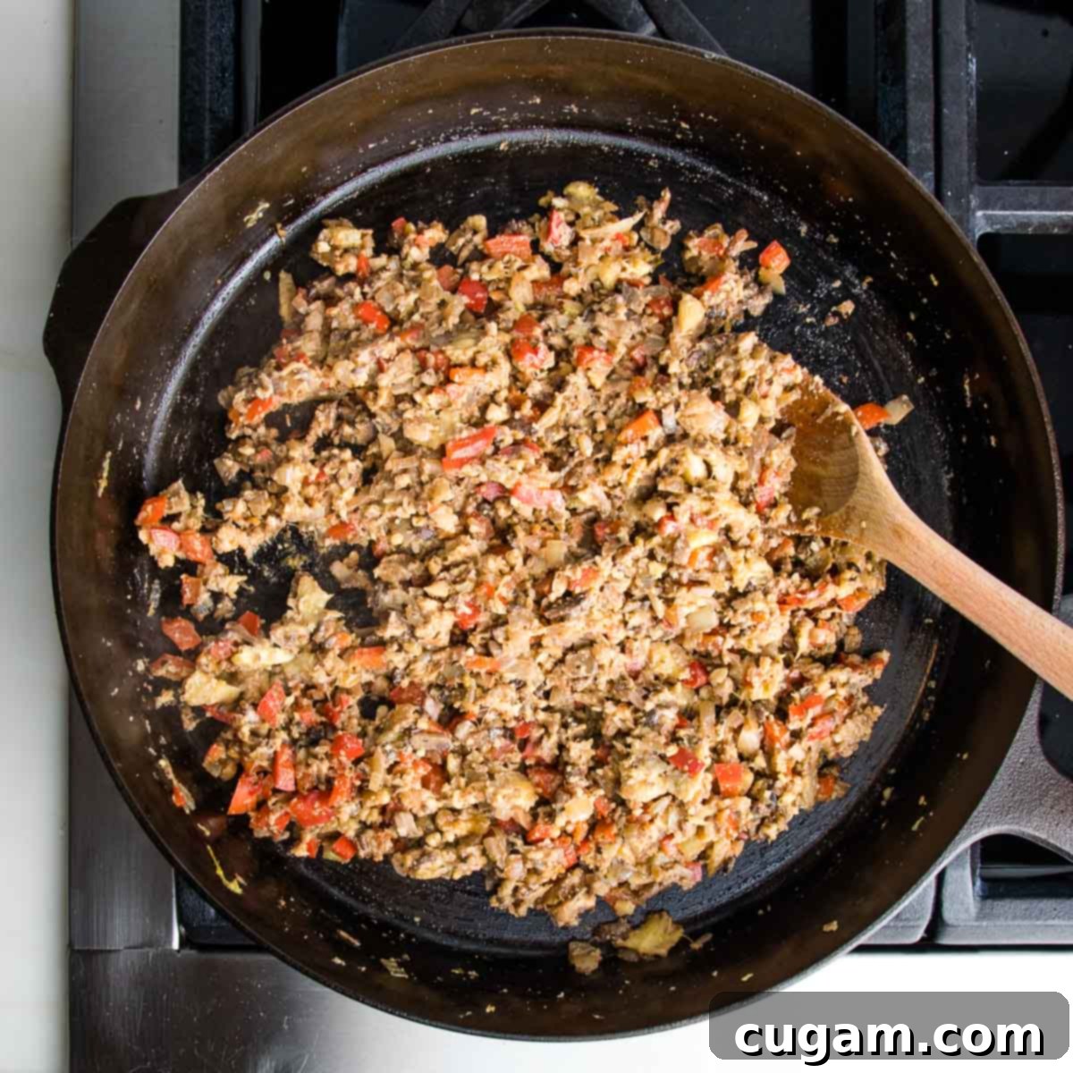 The completed vegan filling for the zucchini boats, featuring a harmonious blend of sautéed vegetables, walnuts, and tamari, thoroughly combined and ready for stuffing.