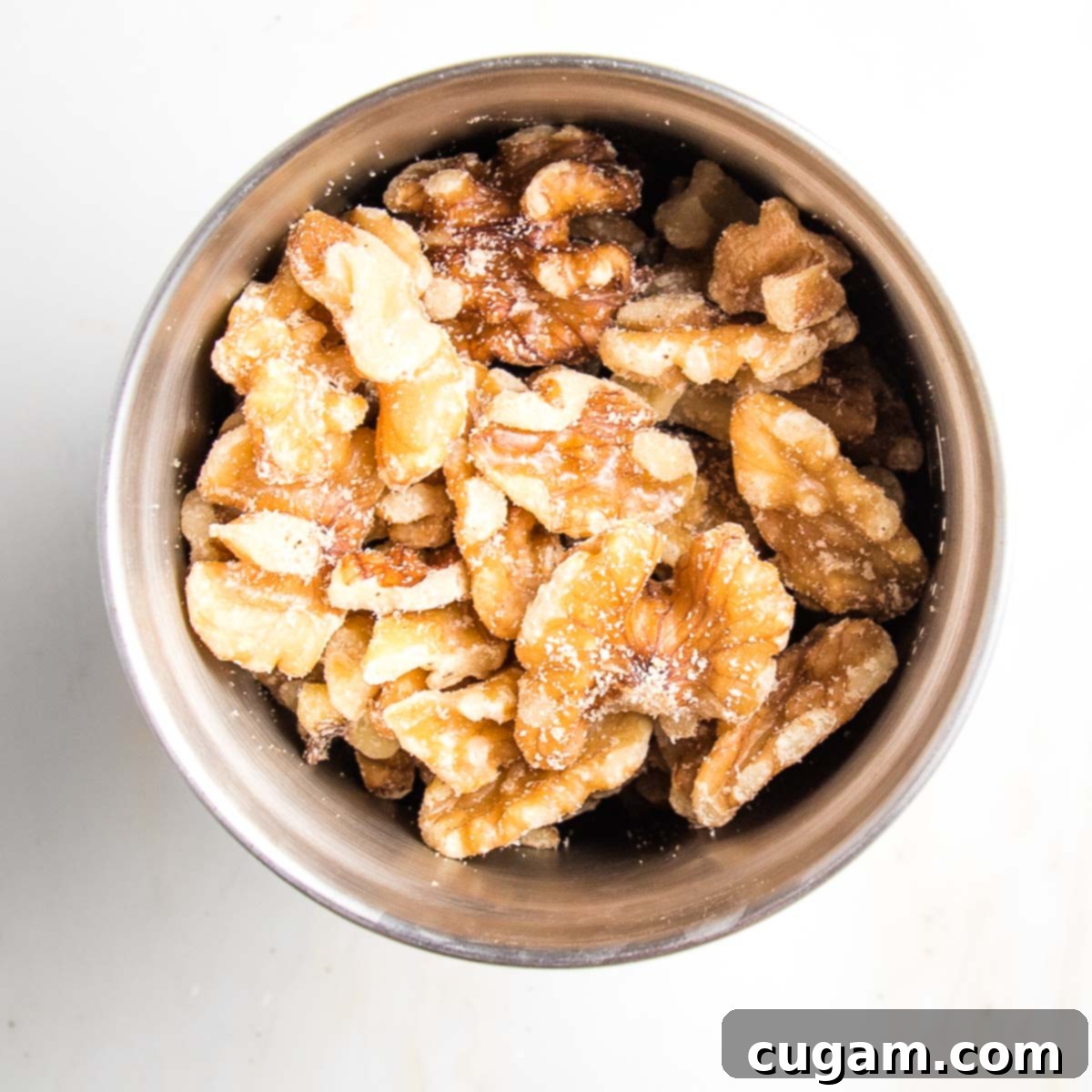 Whole walnuts resting in the bowl of a spice grinder, ready to be processed.