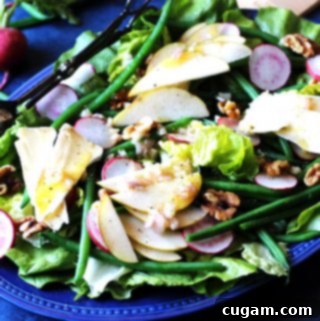 French salad on a blue serving plate, showing fresh and vibrant ingredients.