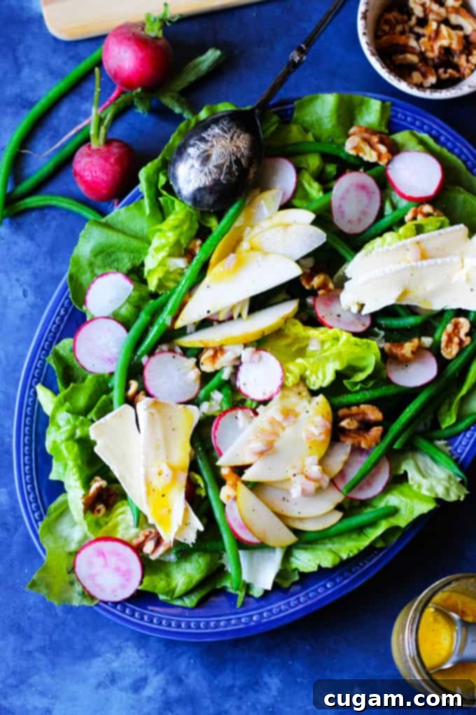 French Salad with Beans, Radishes, Cheese, Pears on a blue serving plate, showcasing a close-up of the delicious textures.