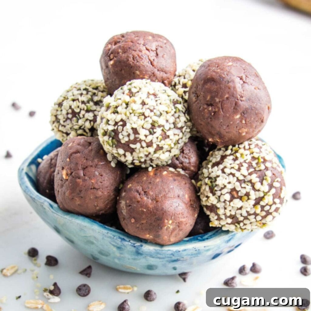 Close up of a blue bowl filled with edible vegan chocolate balls. Some have been rolled in hemp seeds.