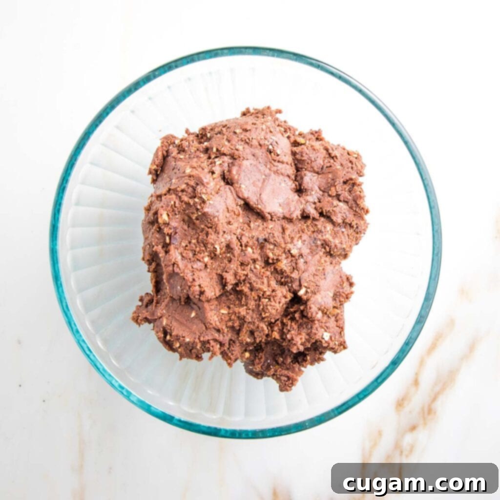 Raw chocolate cookie dough in a glass bowl.