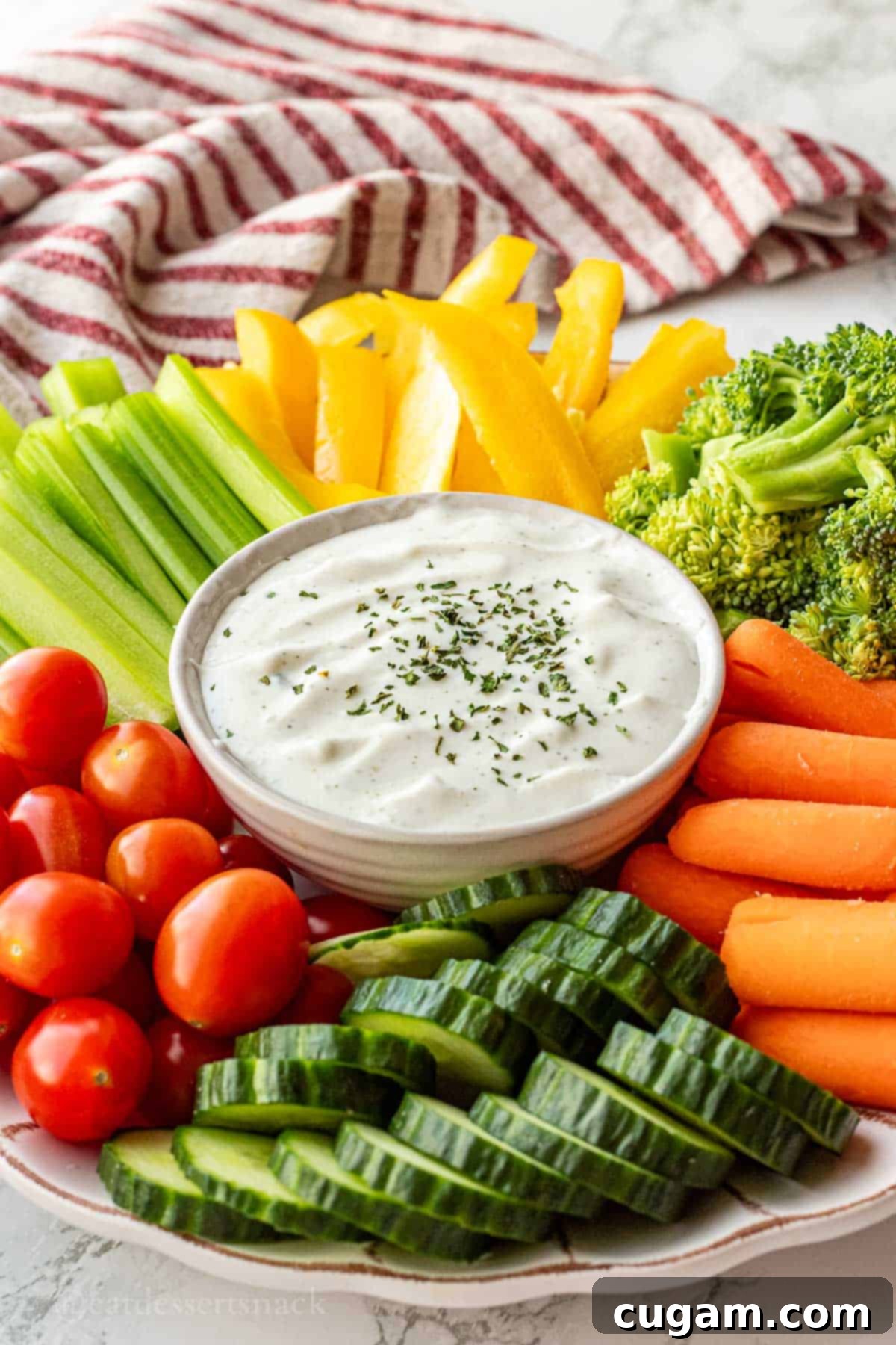 Bowl of ranch cottage cheese dip on tray of colorful fresh veggies, ready to serve.
