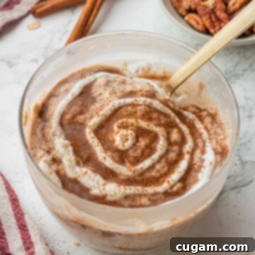 Swirl of greek yogurt on cinnamon roll overnight oats.