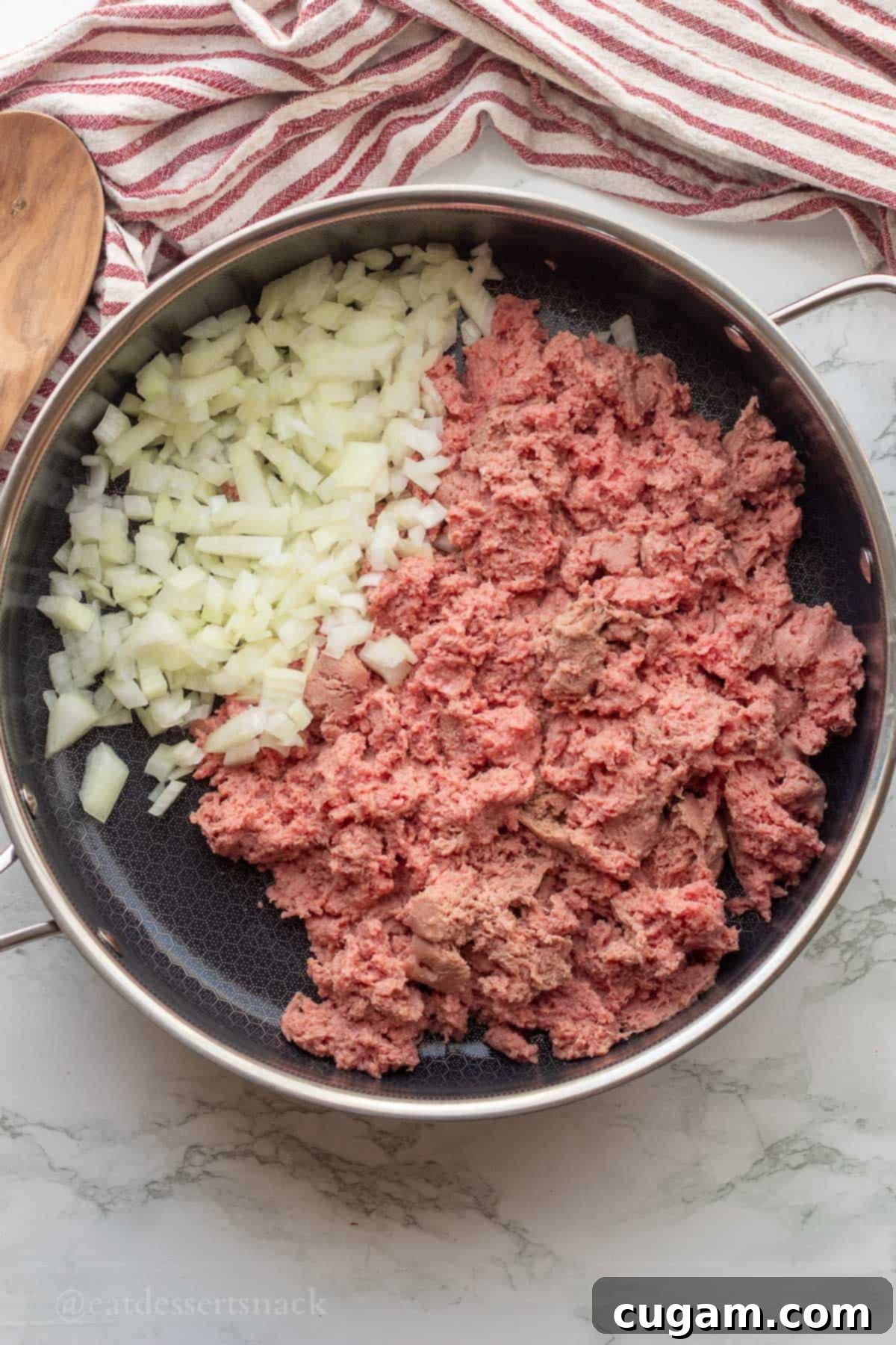 Raw ground turkey and onions in metal pan.