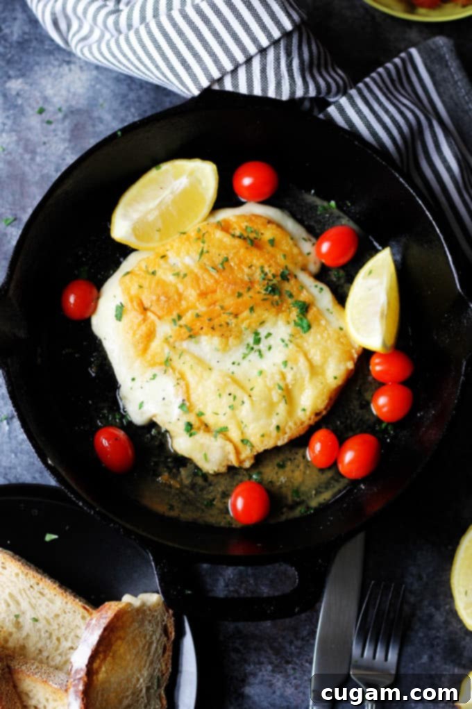 Saganaki - Greek Fried Cheese in a skillet with lemon wedges and cherry tomatoes ready to be served
