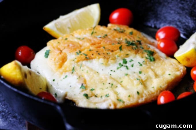 Greek Fried Cheese Saganaki sizzling in a cast iron skillet with lemon wedges