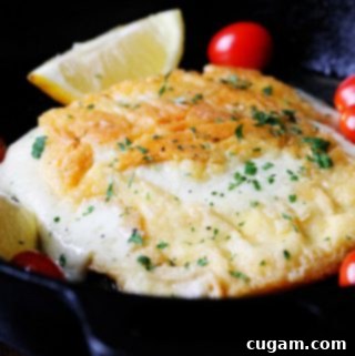 Greek Fried Cheese Saganaki in a skillet with lemon wedges