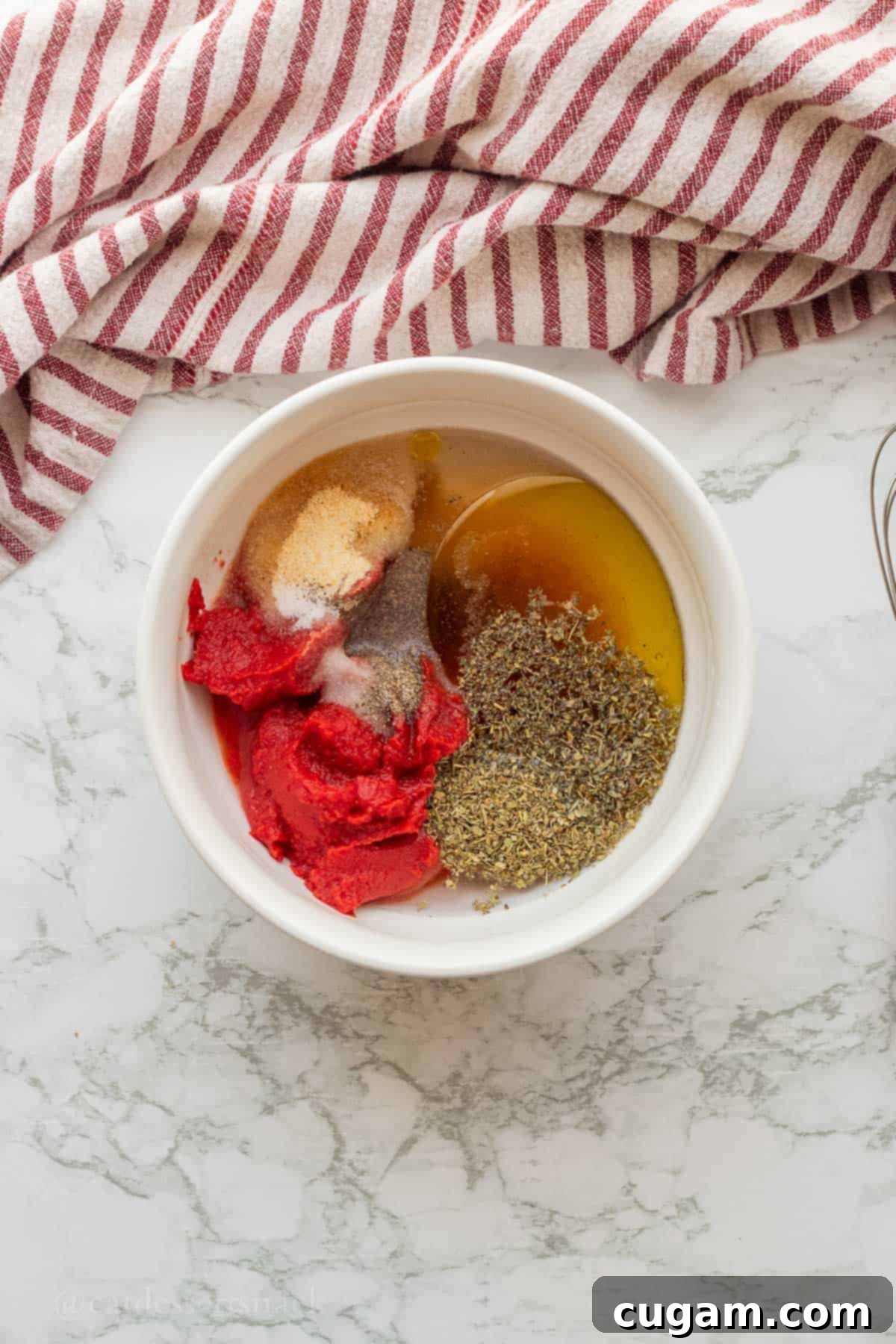 All measured ingredients for the pizza sauce combined in a mixing bowl.