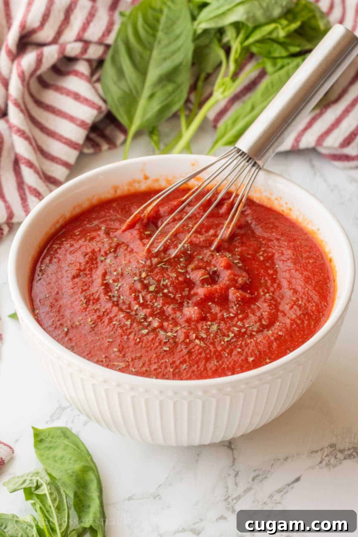 Whisking the pizza sauce ingredients together in a bowl until smooth and well combined.