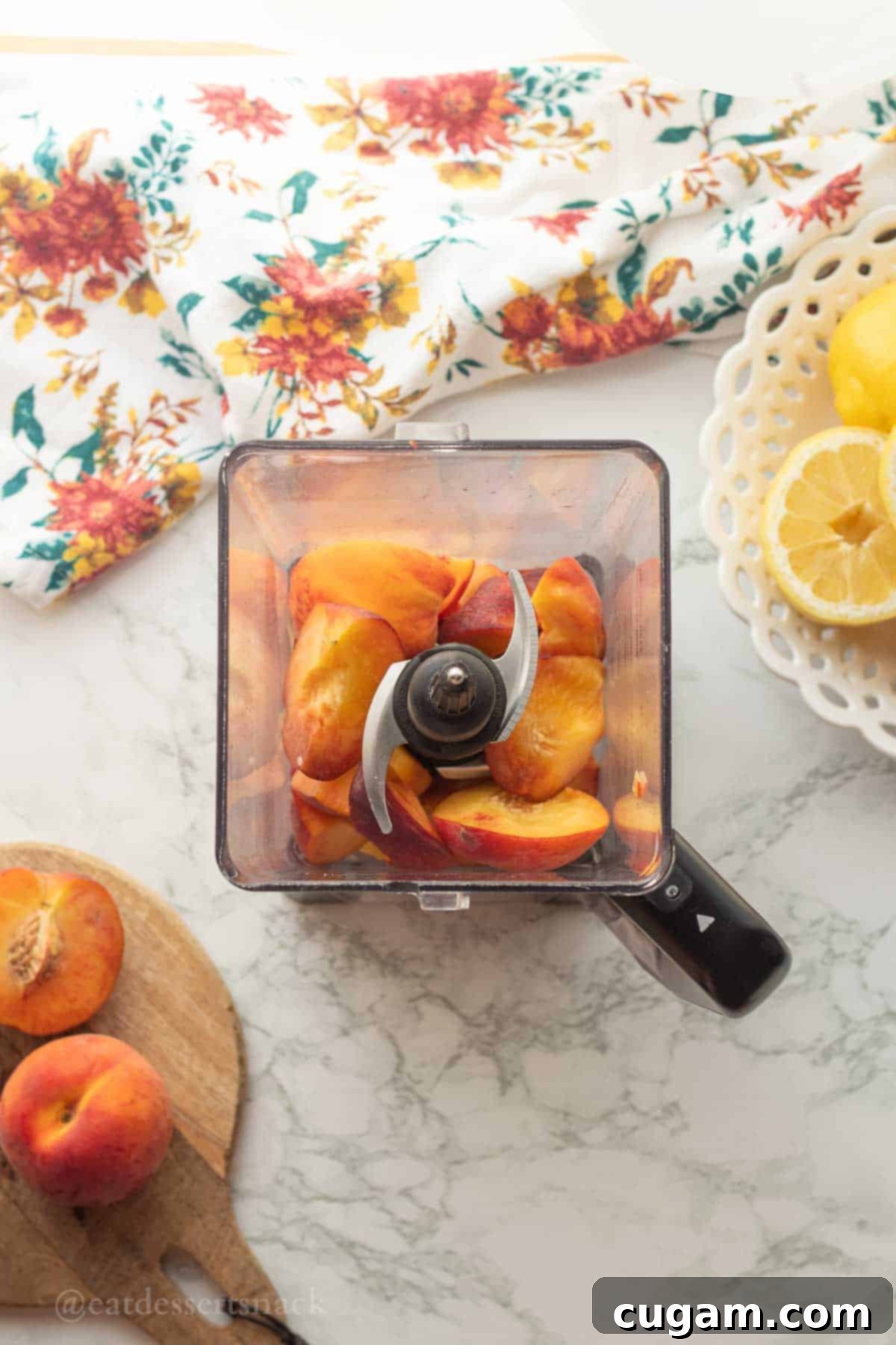 Freshly sliced peaches placed inside a blender container, ready for processing into a smooth puree.