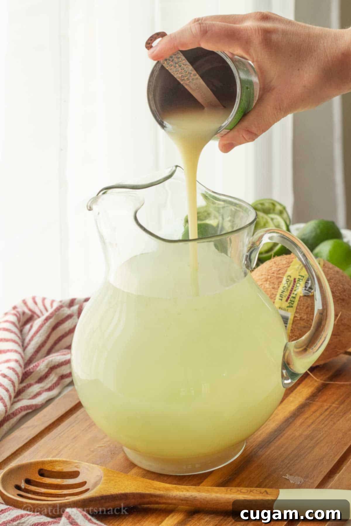 Pouring coconut condensed milk into pitcher.