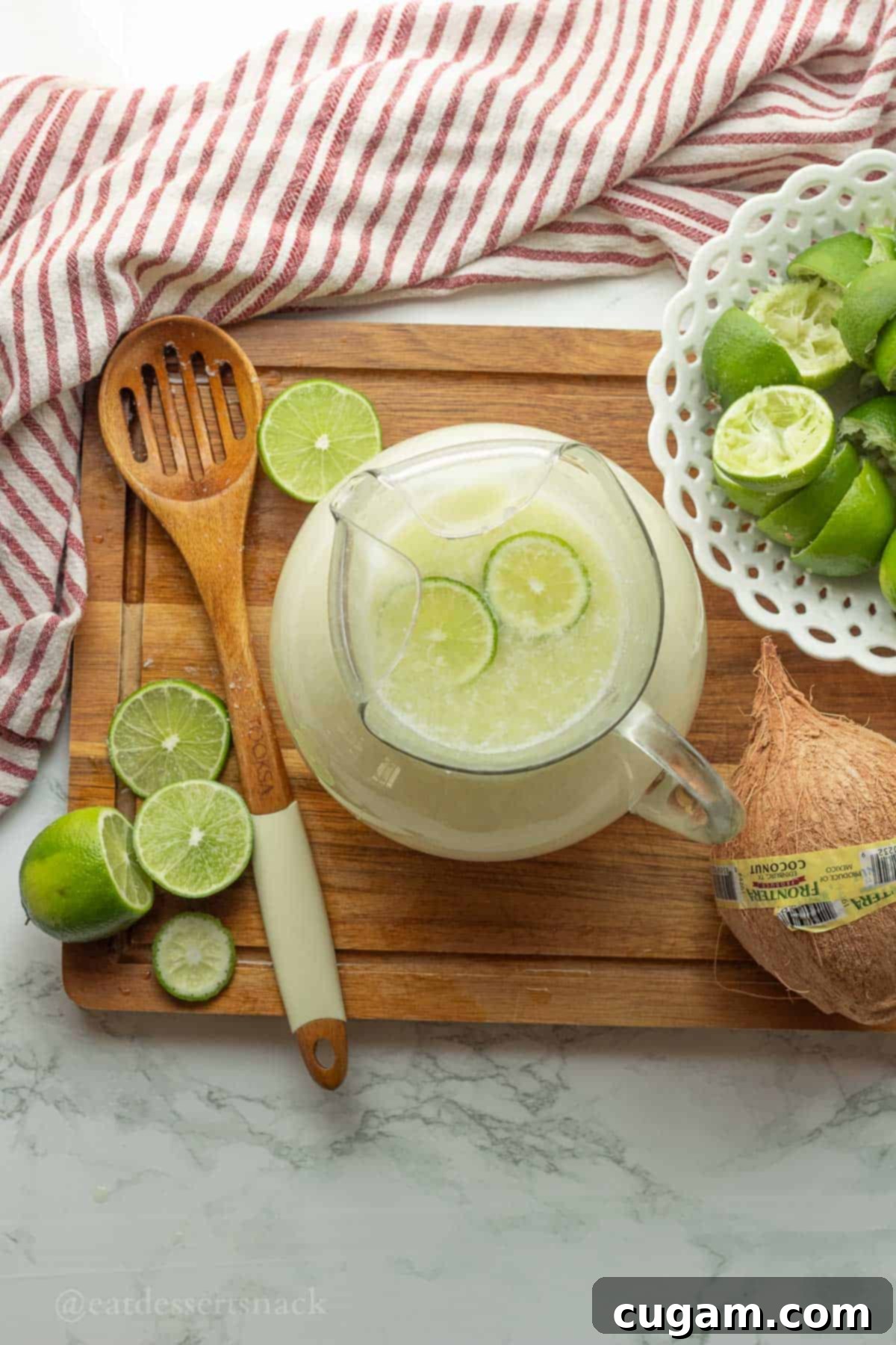 Pitcher of lime drink with lime slices.