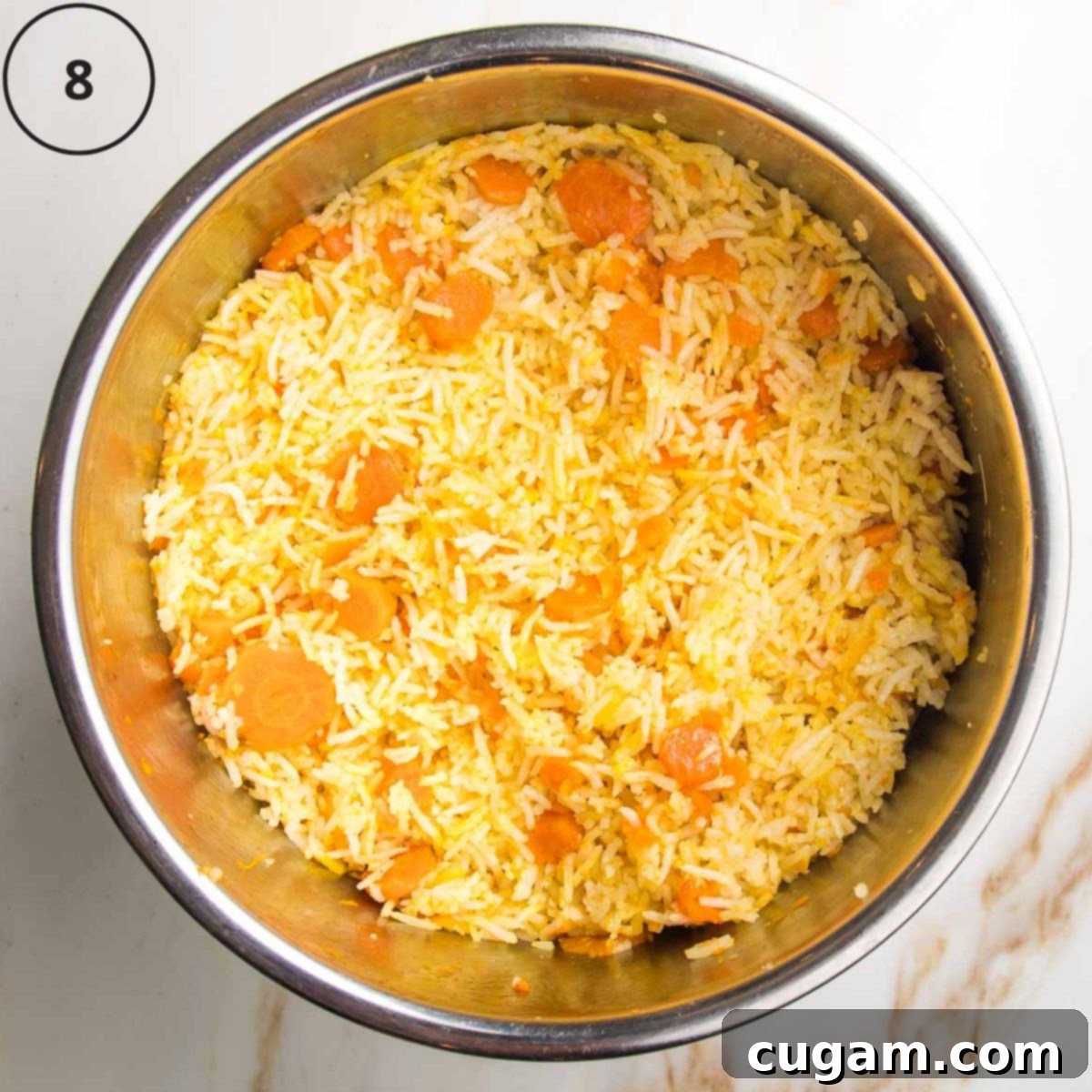 Cooked, fluffy rice with visible carrots and aromatic spices inside the Instant Pot insert, ready to be fluffed with a fork.