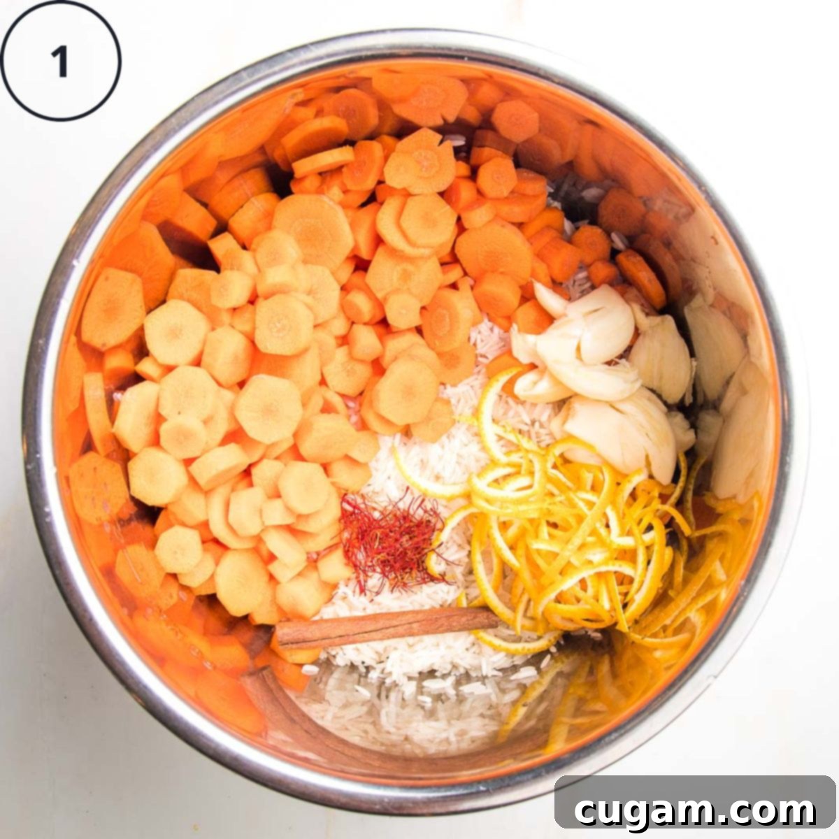 An Instant Pot insert filled with raw basmati rice, bright carrot rounds, whole smashed garlic cloves, fragrant orange peels, a cinnamon stick, and delicate saffron threads, ready for cooking.