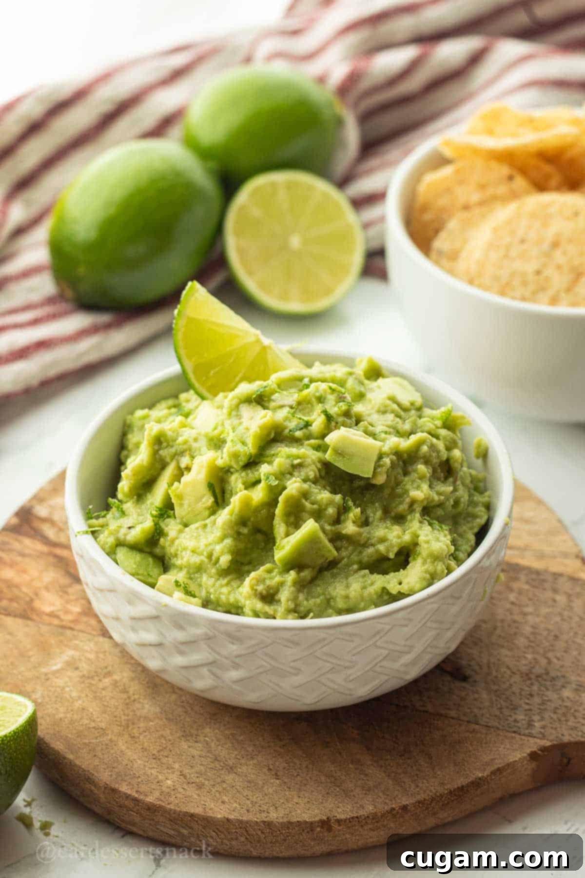 Lime slice in bowl of freshly made guacamole, ready to be served.