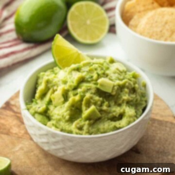 Lime slice in bowl of guacamole.