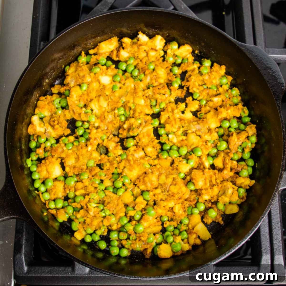 cast iron skillet with samosa filling; potatoes, peas, onions and spices.