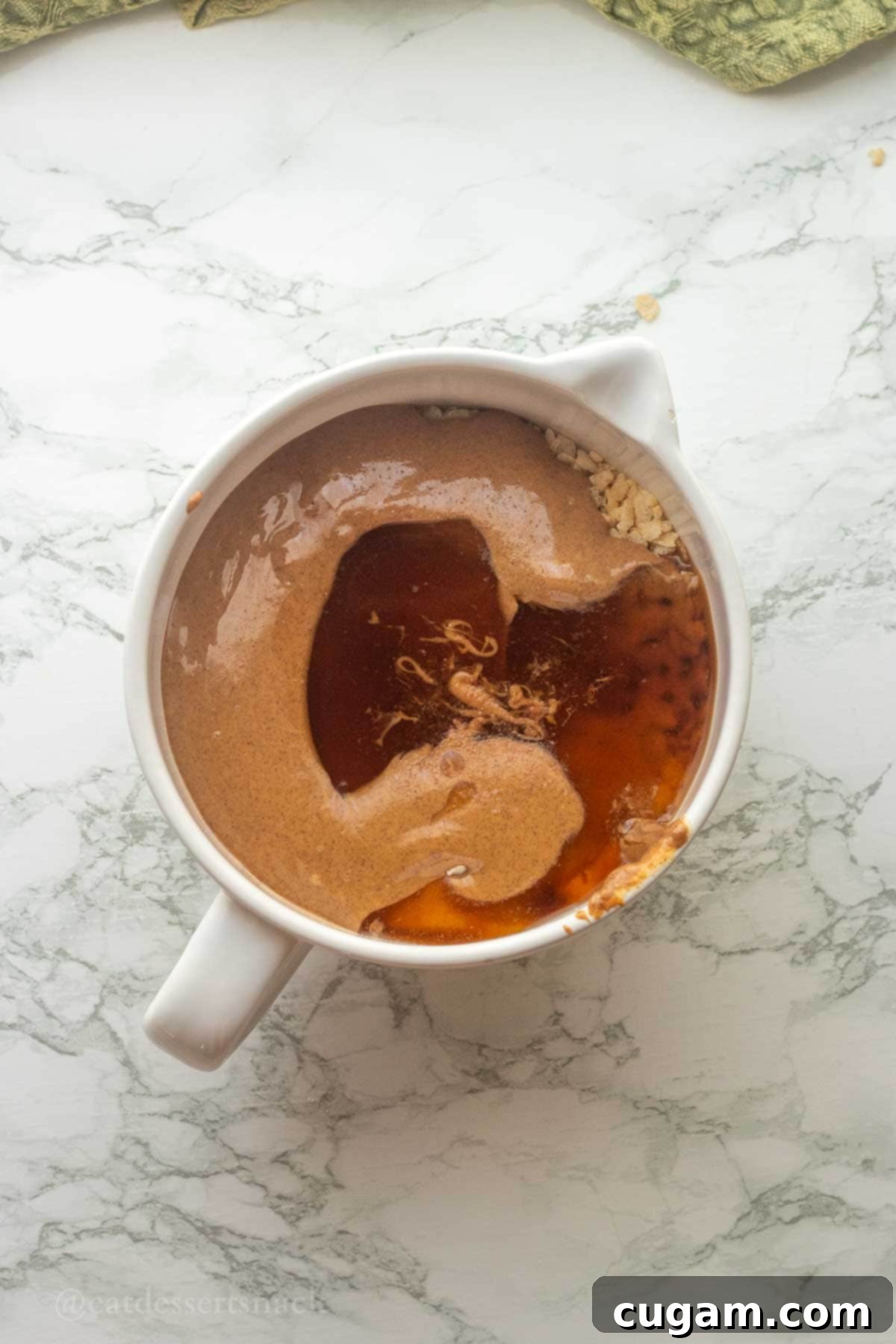 Honey, almond butter on dry ingredients in bowl.
