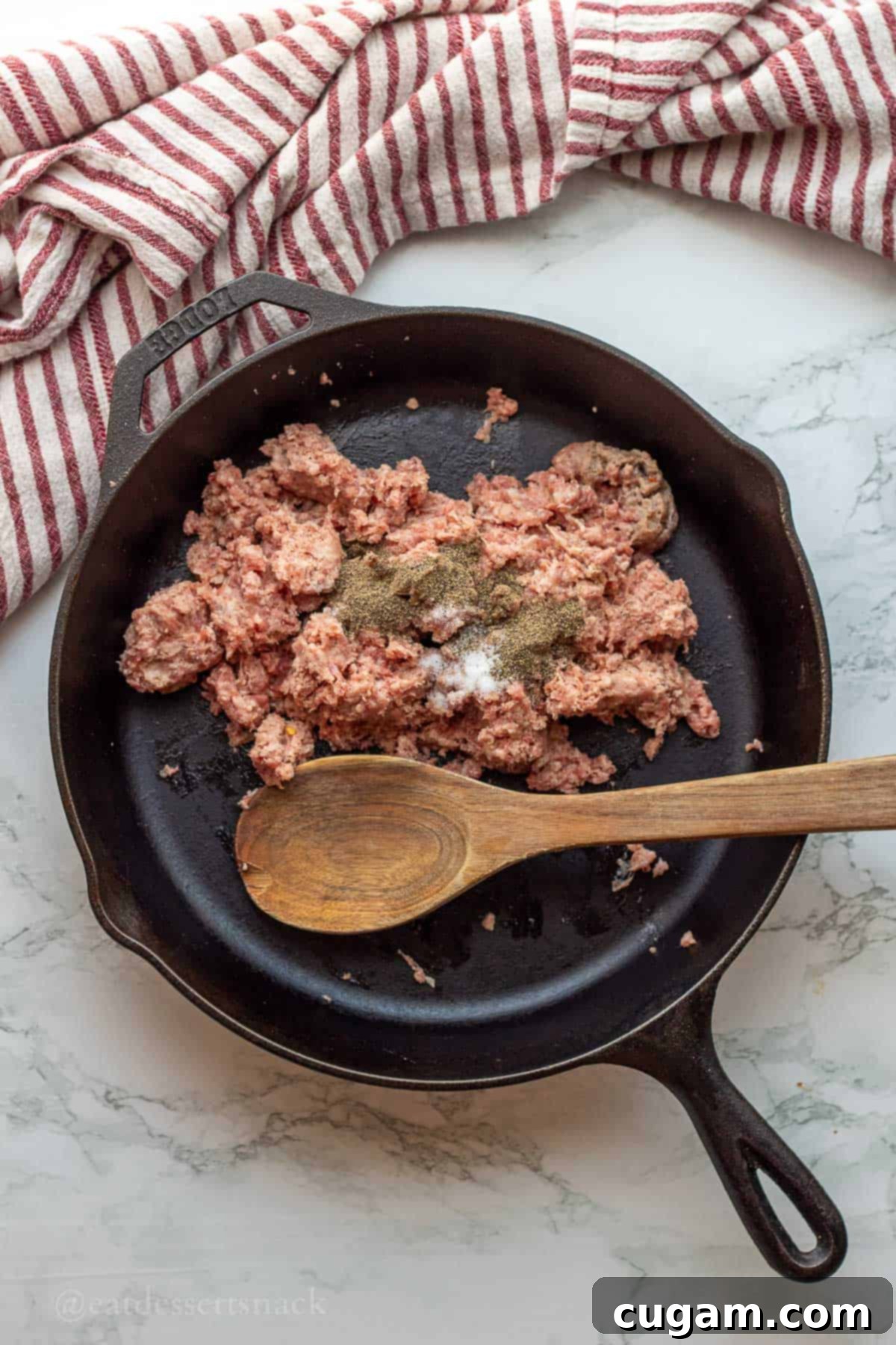 New Mexico Green Chile Sauce 4 Raw sausage with salt and pepper in cast iron pan.