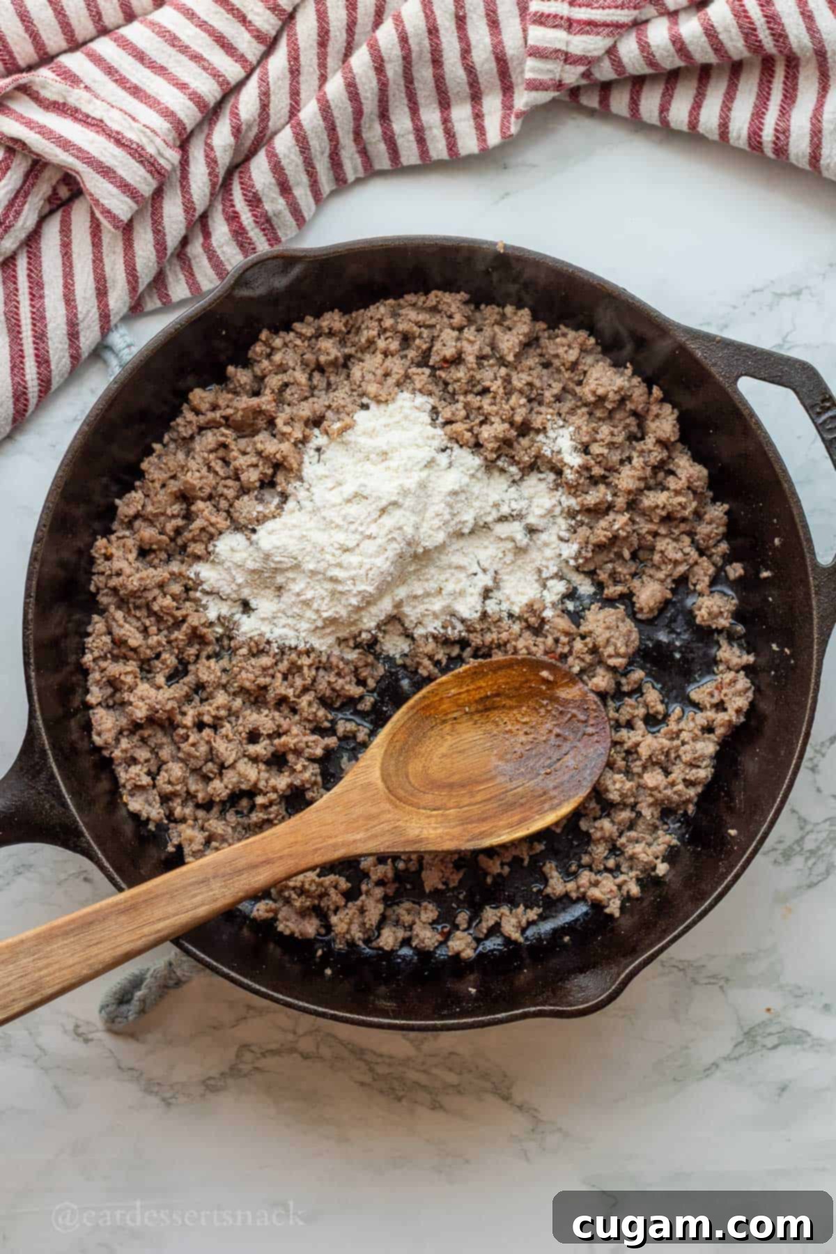 New Mexico Green Chile Sauce 5 Cooked ground sausage in skillet with flour and wooden spoon.