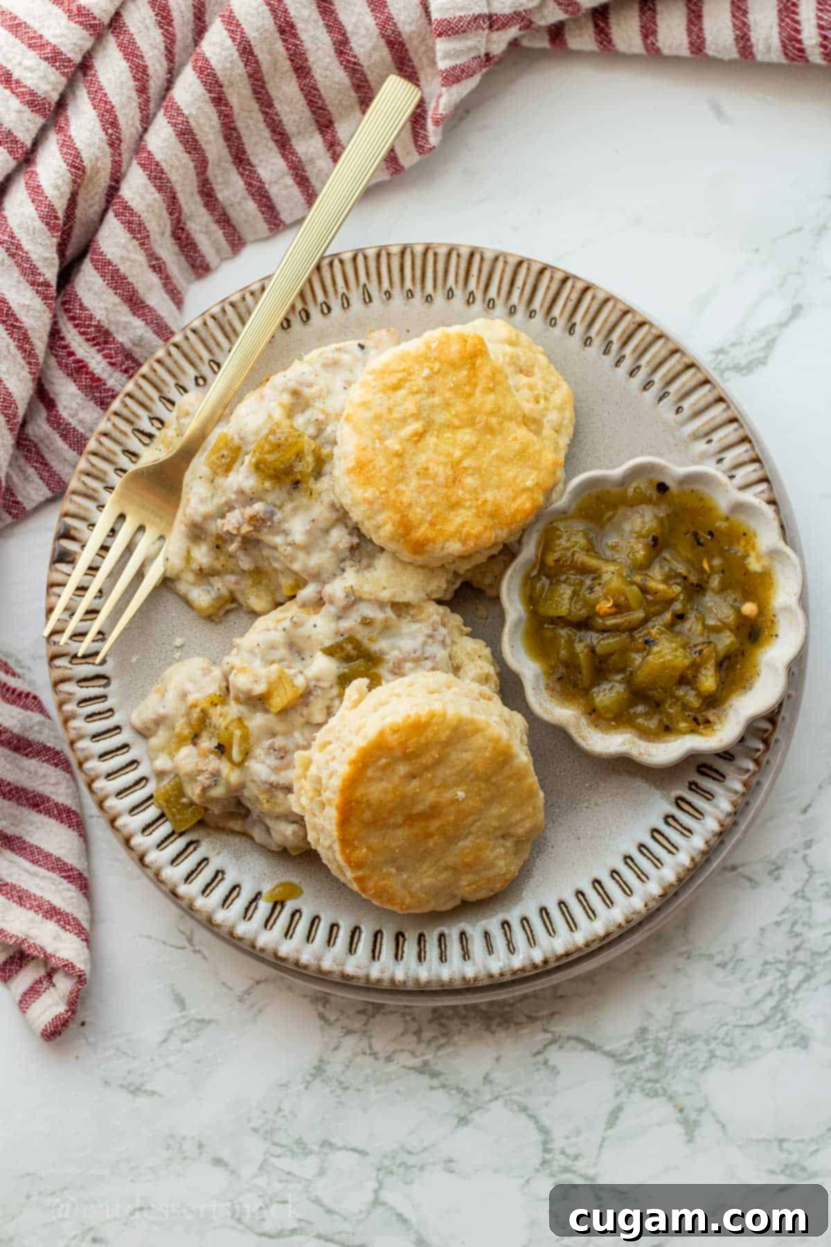 New Mexico Green Chile Sauce 8 Biscuits with a side of green chiles and sausage gravy on plate with fork.