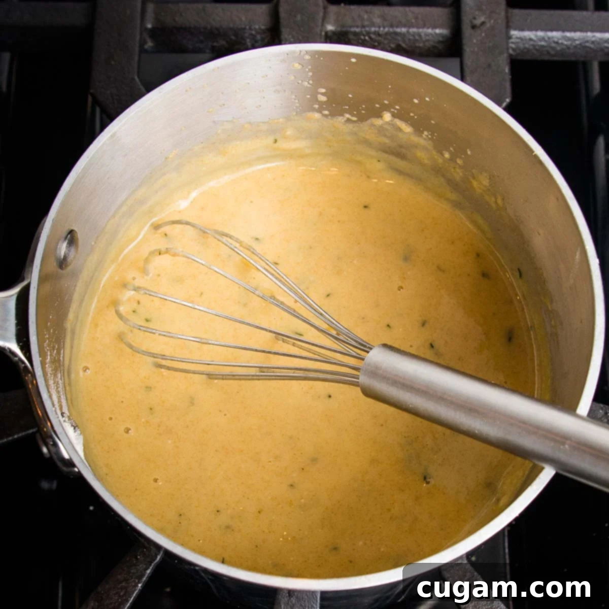 Whisking golden gravy in a small saucepan.