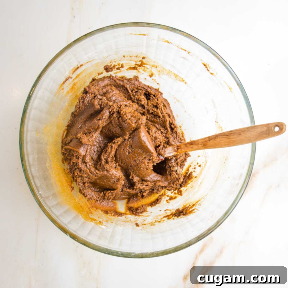 Irresistibly Chewy Vegan Ginger Gems 9 Dough for gingerbread cookies in a glass mixing bowl, with a spatula.