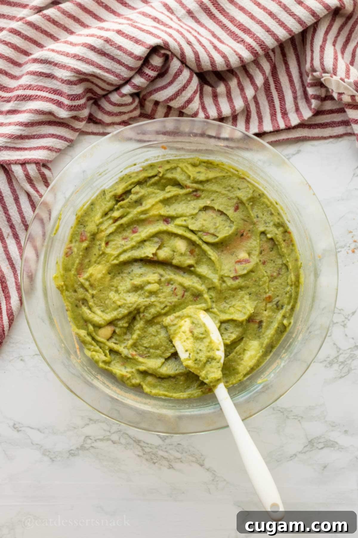 Spooky Spiderweb Taco Dip 5 Smooth layer of fresh guacamole spread over the seasoned refried beans in a pie pan.