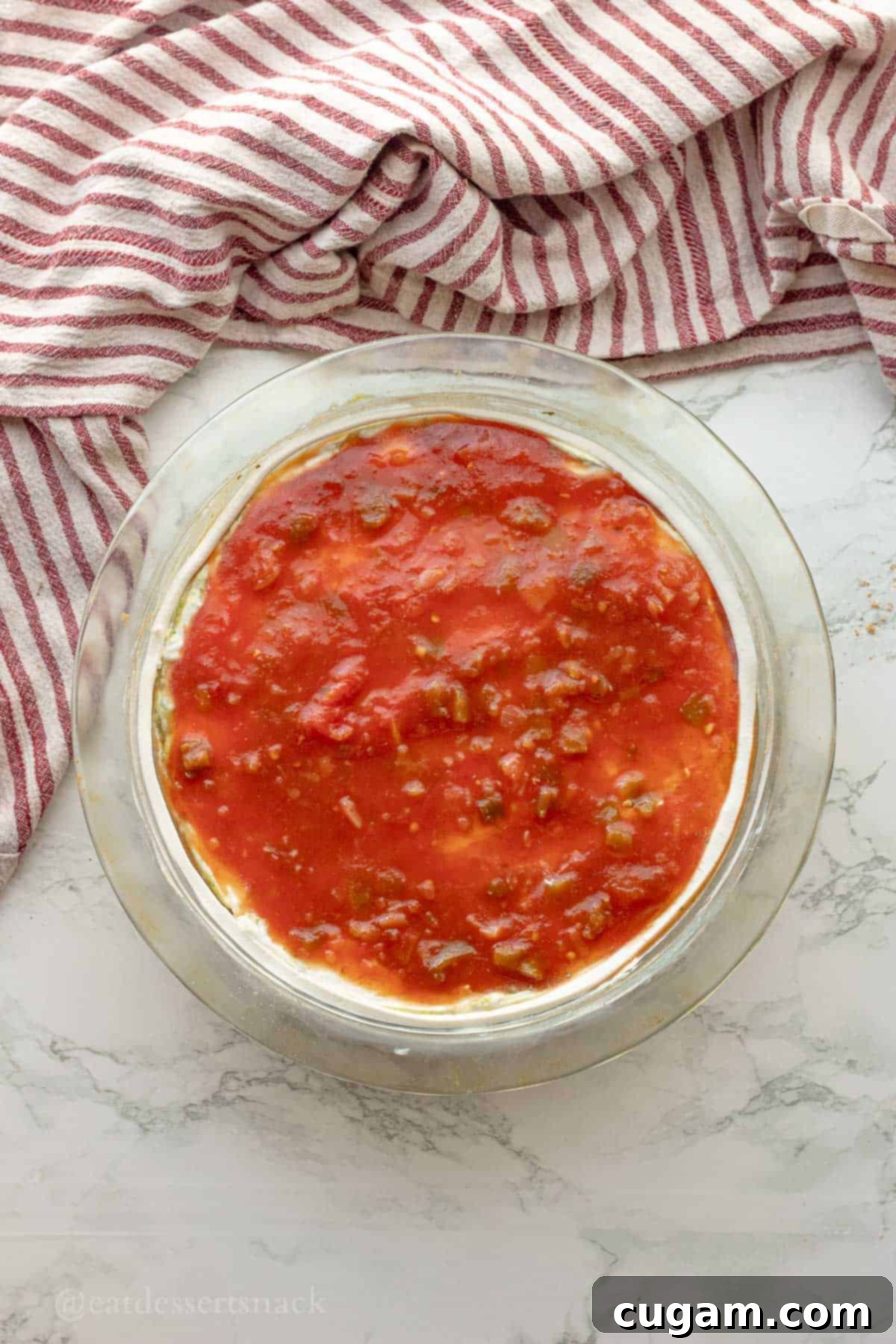 Spooky Spiderweb Taco Dip 7 Zesty salsa spread over the sour cream layer, adding a pop of color and flavor to the multi-layered dip.