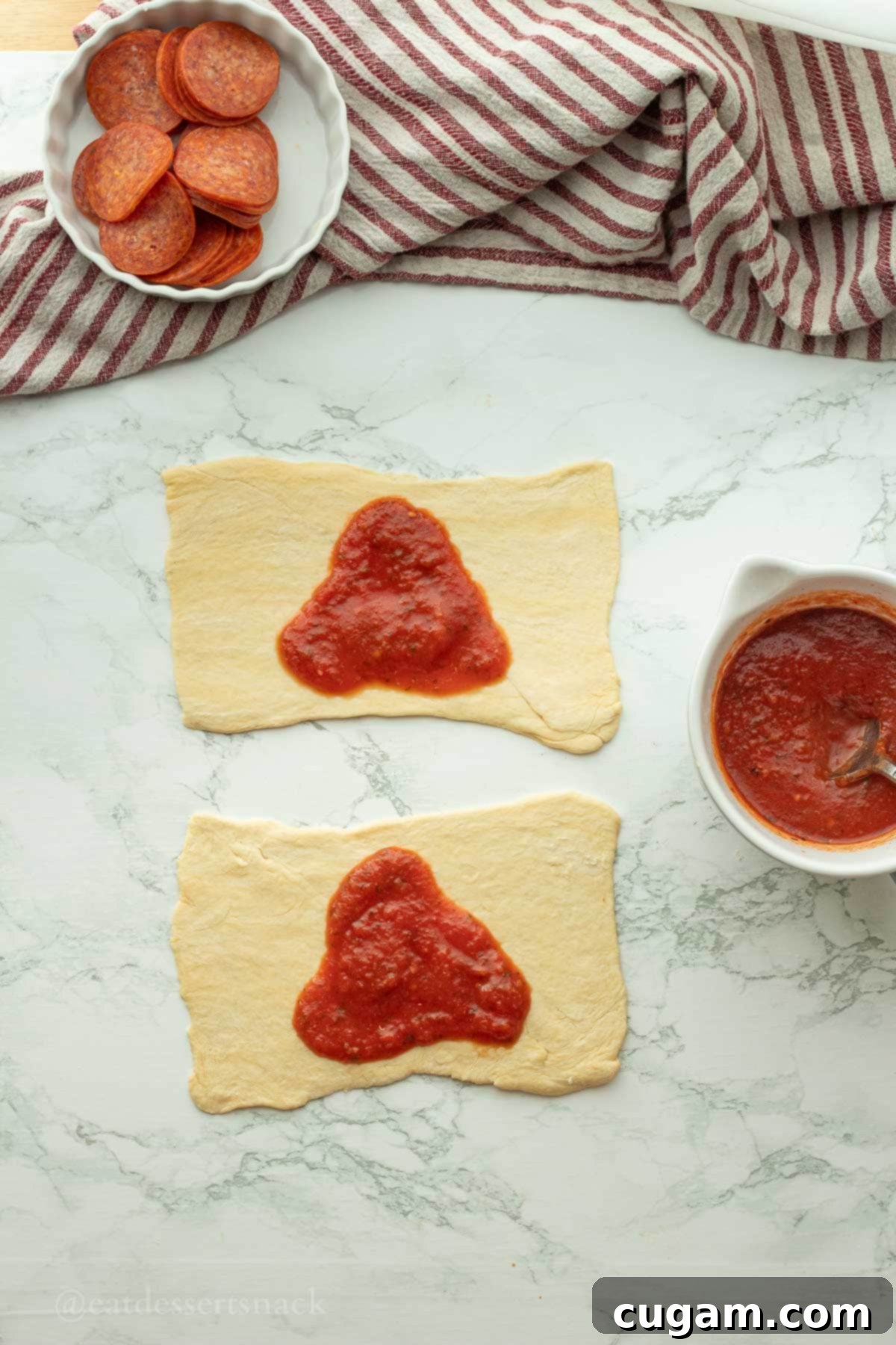 Halloween Witchy Crescent Treats 5 Raw crescent dough with pizza sauce on it.