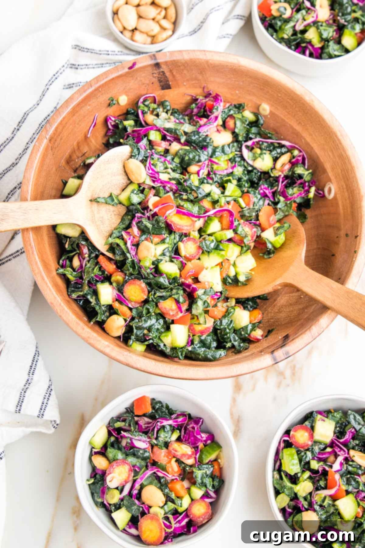 Colorful chopped kale salad in a wooden bowl. 3 small salad bowls filled with same salad.