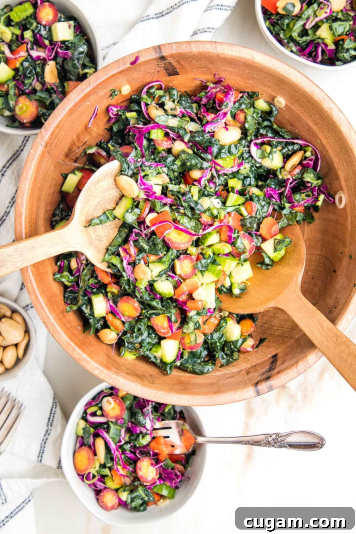 Colorful chopped kale sale in a wooden bowl, along with small bowls filled with same salad.