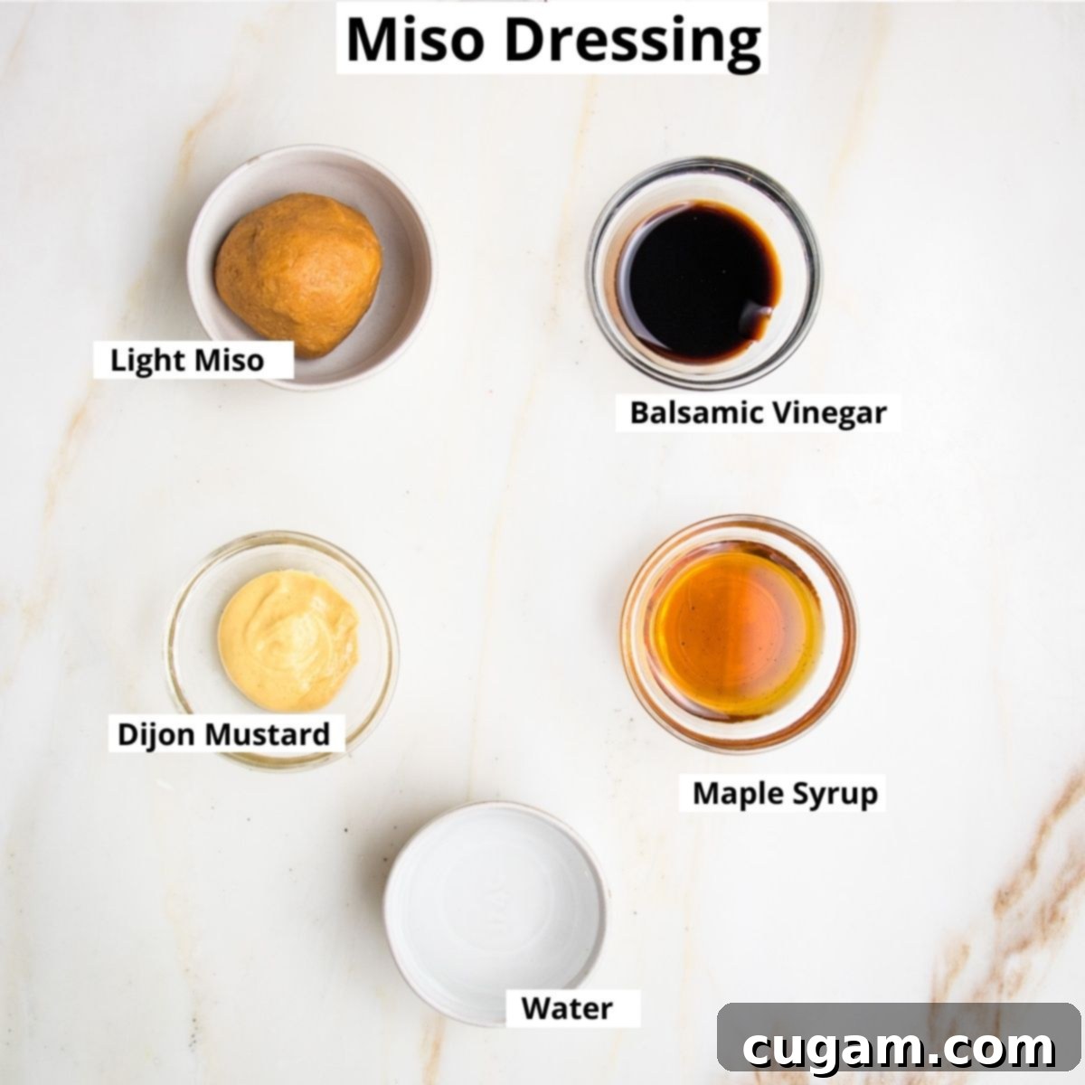 Individual bowls holding the labeled ingredients for miso dressing: rich balsamic vinegar, light miso paste, tangy Dijon mustard, sweet maple syrup, and clear water.