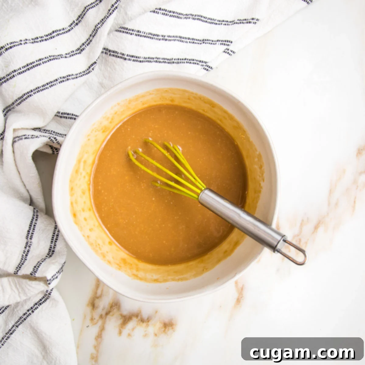 Miso dressing in a small bowl with a whisk.