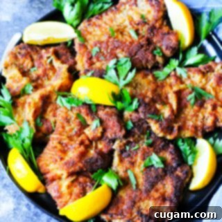 Italian breaded veal cutlets on a plate with blue background