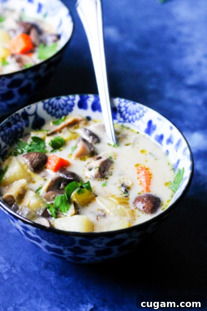 A bowl of chunky homemade Polish mushroom soup, garnished with fresh parsley and ready to be enjoyed.