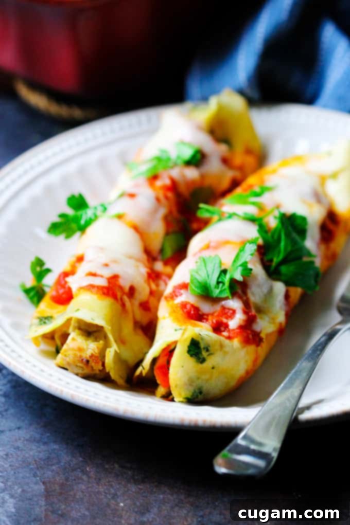Savory Crepes with chicken and mozzarella on a plate with parsley on top, garnished with fresh herbs