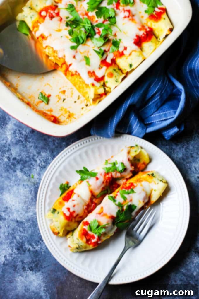 Overhead shot of savory crepes on a plate with the full baking dish in the background, ready to be served