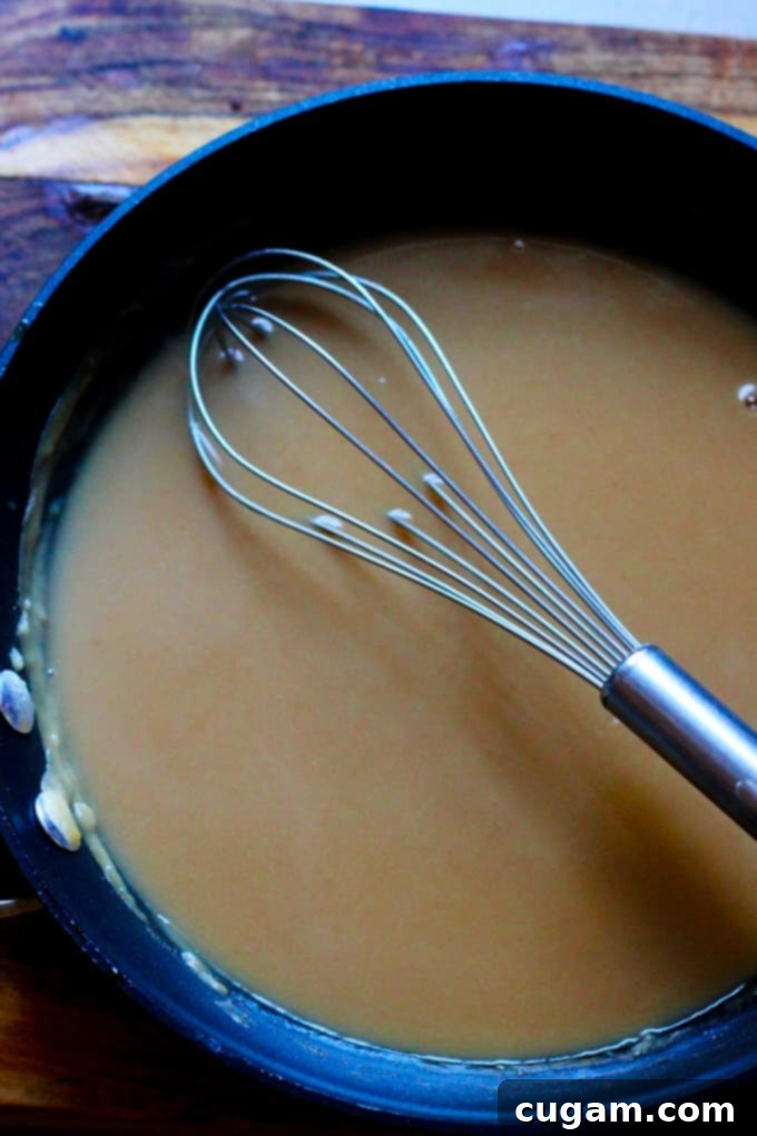 Freshly made easy homemade gravy simmering in a pan on the stovetop