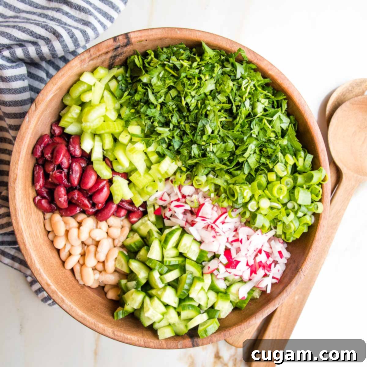 Large wooden bowl with colorful sections of beans and chopped veggies.