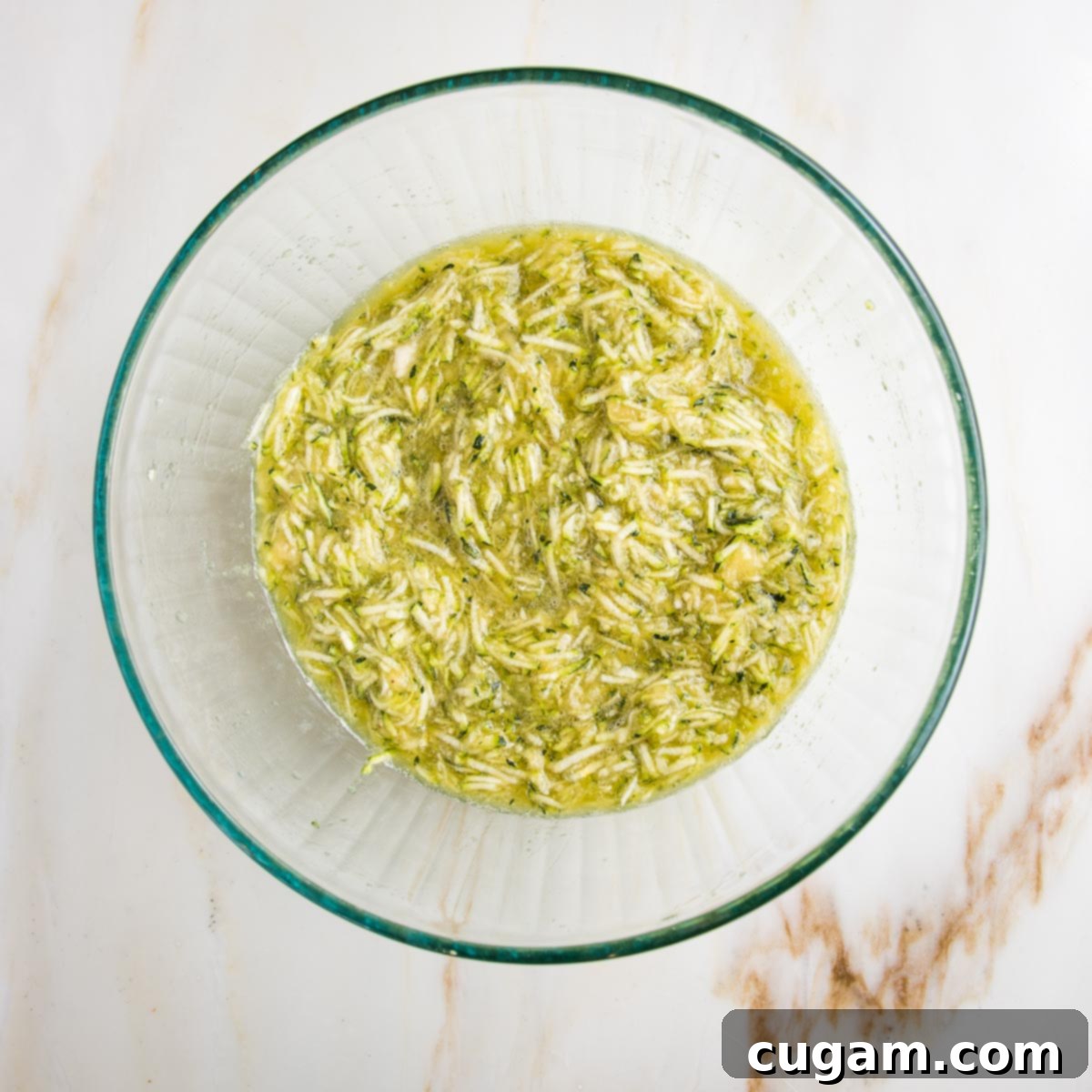 Vegan Zucchini Muffins 6 Mixed up wet ingredients for muffins, including shredded zucchini, showing a harmonious blend of moisture and flavor.